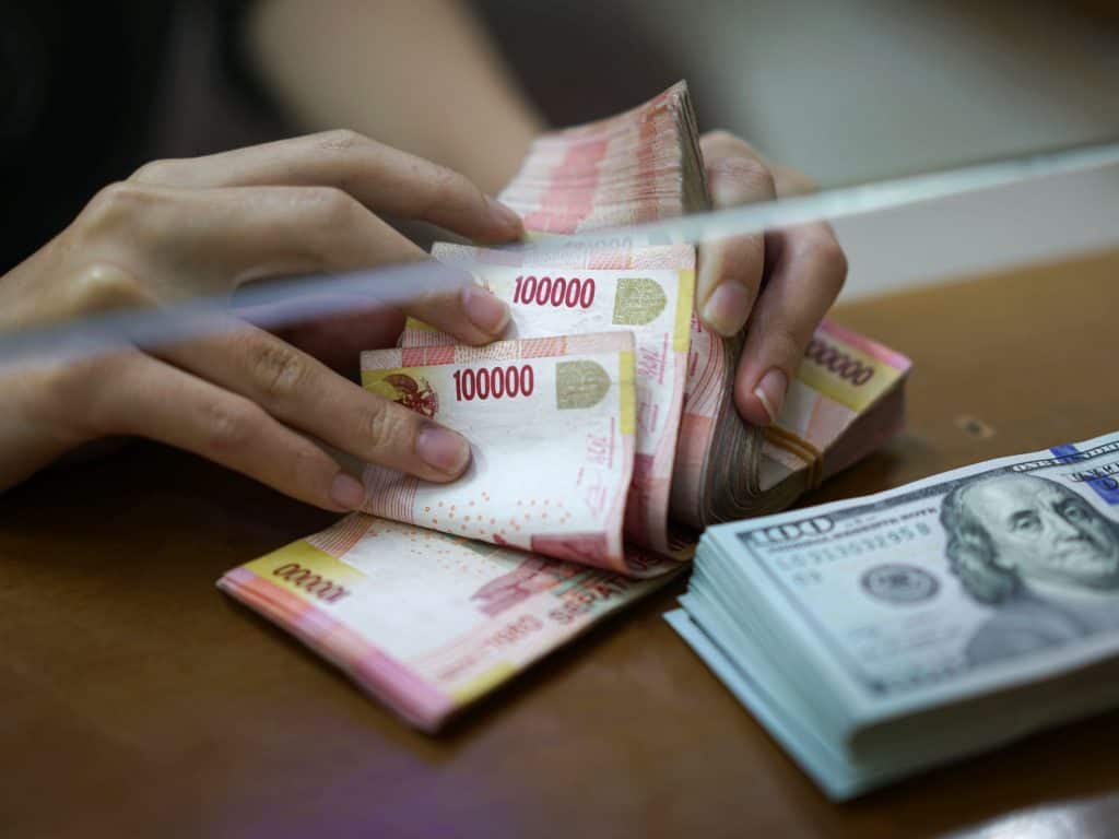 Women Counting Indonesian Rupiah In Exchange for USD - Source: Bloomberg